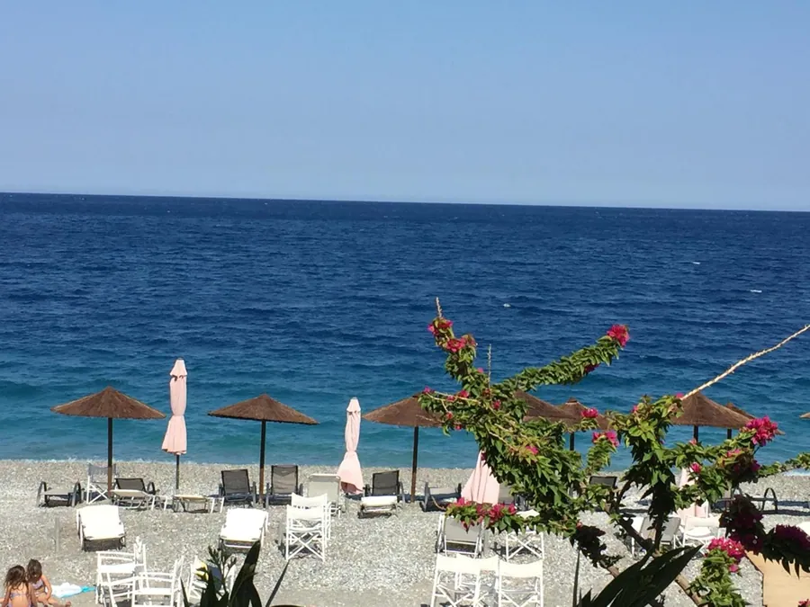 Ομπρέλες στην παραλία και βουκαμβίλια