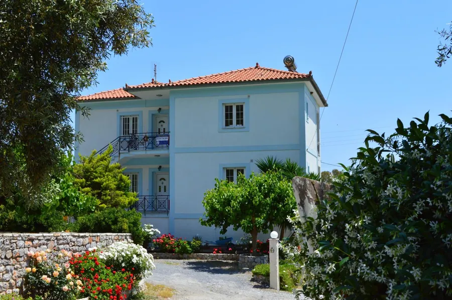 Το σπίτι με τα μπαλκόνια πίσω από τα δέντρα
